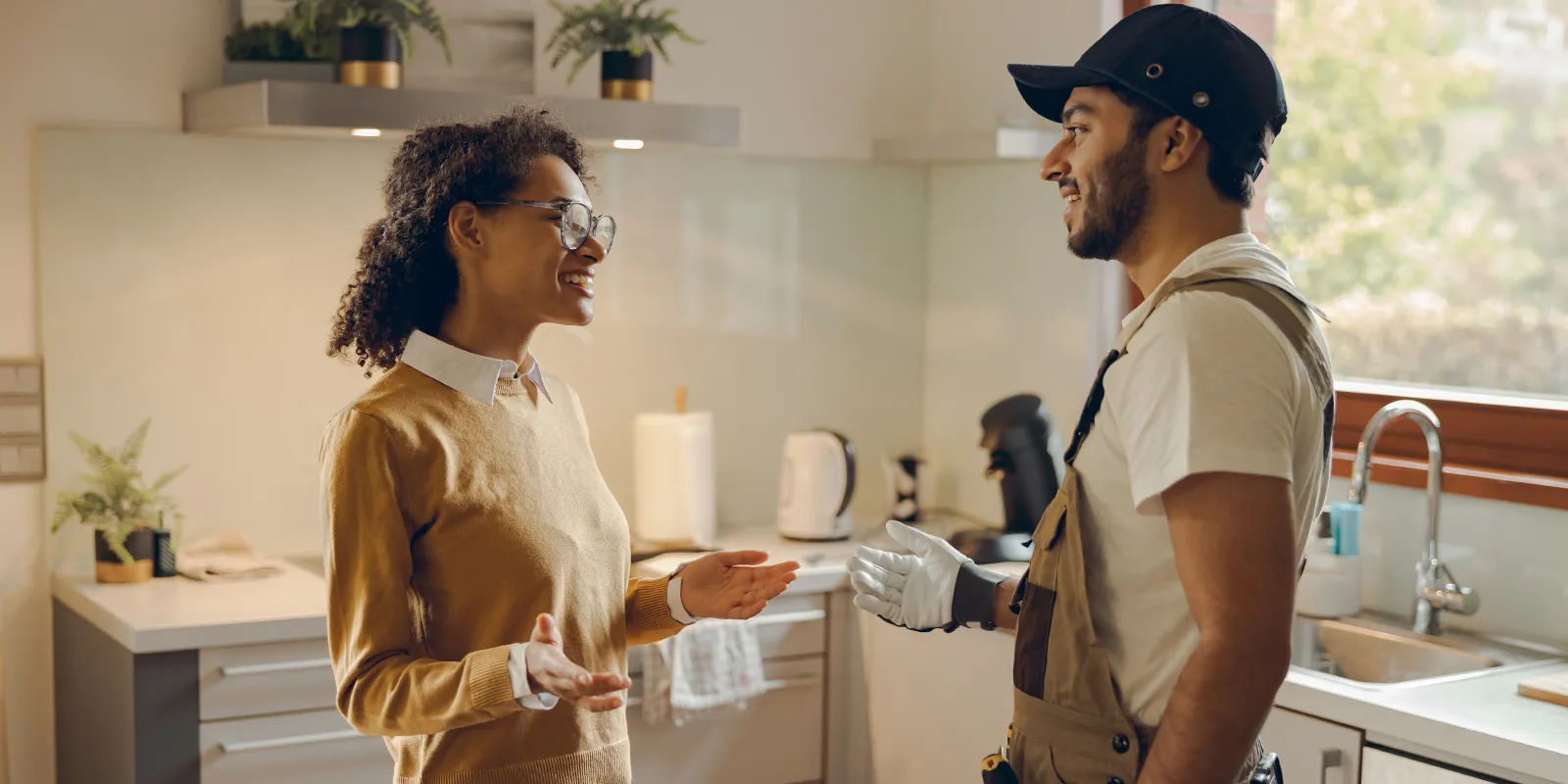 Artisan professionnel discutant avec une cliente dans sa cuisine